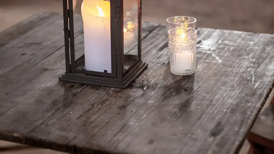 Farol y velas encendidas sobre una mesa de madera